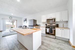 Una cocina con gabinetes blancos y una encimera de madera. en 4 Mi to Lake Erie Condo in Golf Community, en Erie