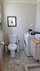 a bathroom with a toilet and a washing machine at Chania Homely Apartments in Souda