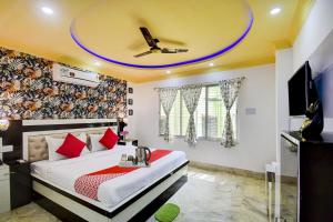 a bedroom with a bed with a ceiling at OYO Flagship The Nest Inn Near Acropolis Mall in Jādabpur