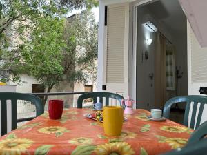 a table with cups and saucers on top at Gli ulivi -Appartamento al centro in Cala Gonone