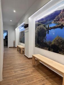 a room with benches and a large painting on the wall at Casa Rural Abuelo Raimundo in Ossa de Montiel