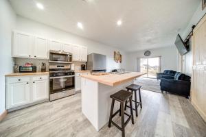 a kitchen with white cabinets and a counter with stools at Erie Vacation Rental with Patio, Near Golf Course! in Erie