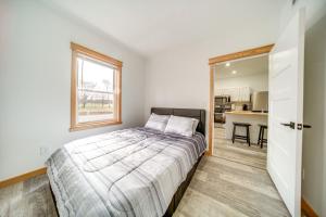 a bedroom with a bed with a window and a kitchen at Erie Vacation Rental with Patio, Near Golf Course! in Erie