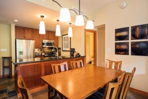 a kitchen and dining room with a wooden table and chairs at Capitol Peak Lodge - CoralTree Residence Collection in Snowmass Village