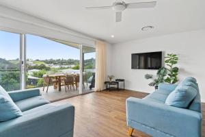 a living room with two blue couches and a table at Valley Way in Lennox Head
