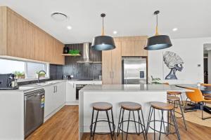 a kitchen with a large island with bar stools at Valley Way in Lennox Head