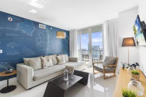 a living room with a couch and a blue wall at Spectacular Balcony View Retreat Resort Amenities in Hallandale Beach
