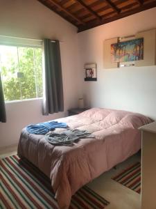 a bed in a bedroom with a window at Chalés lá na roça in Costas