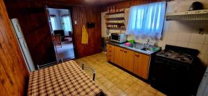 a small kitchen with a stove and a sink at Casa completa para 5 personas. in San Carlos de Bariloche
