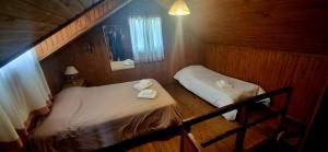 a small room with two beds and a window at Casa completa para 5 personas. in San Carlos de Bariloche +1 photo