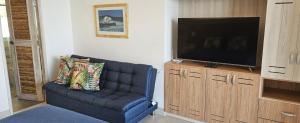 a living room with a blue couch and a flat screen tv at Casa Luna Laguna Beach in Tolú