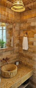 een houten badkamer met een wastafel en een spiegel bij Casa Luna Laguna Beach in Tolú