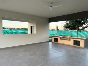 ein leeres Zimmer mit einem großen Fenster und einem Tisch in der Unterkunft Casa V25 in Querétaro