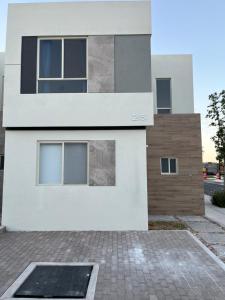 ein weißes Haus mit einer steinernen Einfahrt davor in der Unterkunft Casa V25 in Querétaro