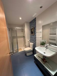a bathroom with a toilet and a sink and a shower at Apartamento Las Arcillas in Teruel
