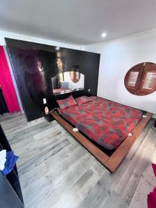 een slaapkamer met een groot bed en een rood dekbed bij La Kasbah de l'ile Fadiouth in Joal-Fadiout