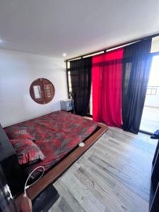 een slaapkamer met een bed en rode gordijnen bij La Kasbah de l'ile Fadiouth in Joal-Fadiout