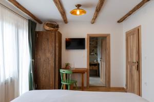 a bedroom with a bed and a desk and a table at Butina Guesthouse in Kuterevo