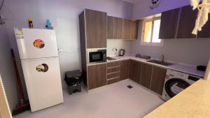 uma cozinha com um frigorífico branco e um micro-ondas em أنين الحالمه em Durat Alarous