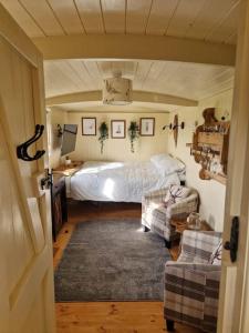 a bedroom with a bed and two couches in it at Shepherds haven hut Near Padstow in Saint Issey