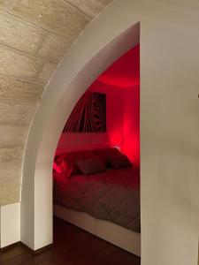 Schlafzimmer mit einem Bett mit roter Beleuchtung in der Unterkunft Sweet Aura in Brindisi