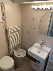 a bathroom with a white toilet and a sink at Sweet Aura in Brindisi