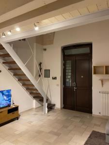 un soggiorno con scala, porta e televisore di Sweet Aura a Brindisi