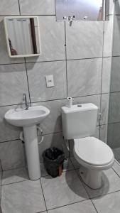 y baño con aseo y lavamanos. en Apartamento próximo ao Aeroporto de Florianópolis., en Florianópolis