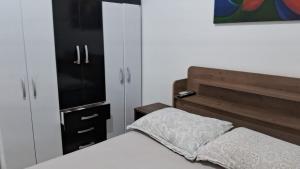 a bedroom with a bed and a dresser and a closet at Apartamento próximo ao Aeroporto de Florianópolis. in Florianópolis