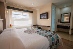 um quarto com uma grande cama branca e um lavatório em HOTEL ECLIPSE TOLUCA em Toluca