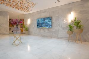 فندق روحة المقام في Ajyad: غرفة معيشة مع تلفزيون على جدار بالنباتات