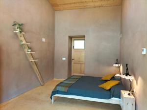 a bedroom with a bed and a staircase at Mas la Llum, la casa de palla in Arens de Lledó