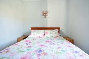 - une chambre dotée d'un lit avec un couvre-lit floral dans l'établissement A Casa Vella de Laura, à Vilagarcía de Arousa