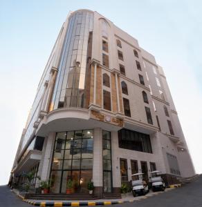 فندق روحة المقام في Ajyad: مبنى أبيض طويل مع نافذة كبيرة