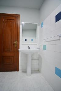 La salle de bains est pourvue d'un lavabo et d'une porte en bois. dans l'établissement A Casa Vella de Laura, à Vilagarcía de Arousa