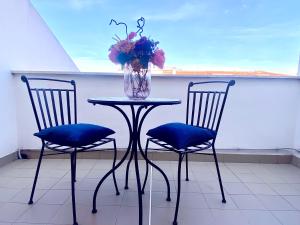 un tavolo con due sedie e un vaso con fiori di CasAzzurra a Ortona