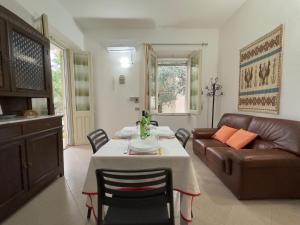 un soggiorno con un tavolo e un divano di Gli ulivi -Appartamento al centro a Cala Gonone