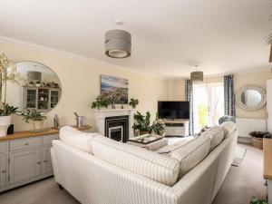 uma sala de estar com um sofá branco e uma lareira em Coral House em Cromer