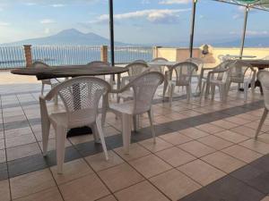 un grupo de mesas y sillas en un techo en Sunset Shores Oasis - Gulfview Haven Rooms with a View, strategic for Pompeii, Amalfi, Capri, and on the Road to Sorrento- progetto sociale Artigiani della preziosità, en Castellammare di Stabia