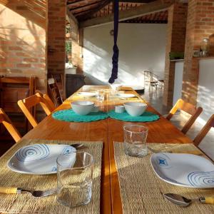 a wooden table with plates and bowls on it at Espaço Circular in Itacaré