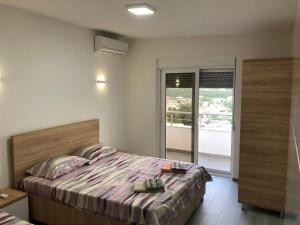 1 dormitorio con 1 cama grande y balcón en Home REX, en Ulcinj