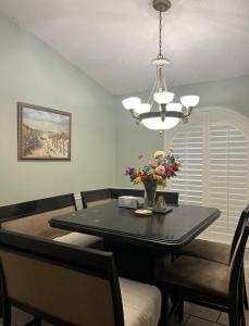 una sala da pranzo con tavolo nero e lampadario pendente di Guest House In Cantonment a Jacksonville