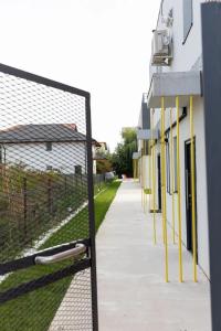 einen Zaun mit gelben Stangen neben einem Gebäude in der Unterkunft Sky Residence Airport Otopeni no 1 in Otopeni