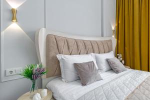 1 dormitorio con 1 cama con almohadas blancas en Apart Astana, Sat City возле Хан-Шатыра, en Astana