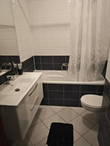 een badkamer met een wastafel, een bad en een toilet bij VIP lounge - self check in in Osijek