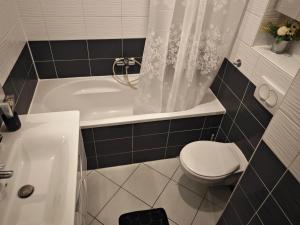 een badkamer met een bad, een toilet en een wastafel bij VIP lounge - self check in in Osijek