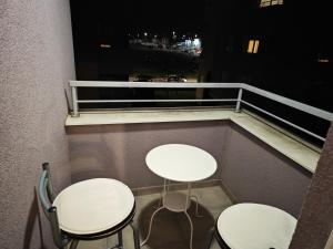 2 tafels en 2 stoelen op een balkon 's nachts bij VIP lounge - self check in in Osijek