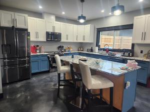 una cocina con armarios azules y una gran isla con sillas en Elysian Lakeview Retreat, en Vernon