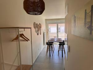 a hallway with a table and stools in a room at La Cabane Nature 400m de la plage in Mimizan