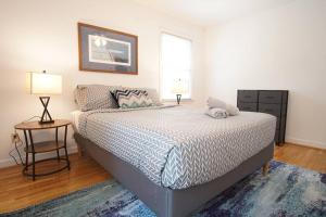 a bedroom with a bed and a table and two lamps at Spacious family friendly home with game room by UNC Charlotte in Charlotte